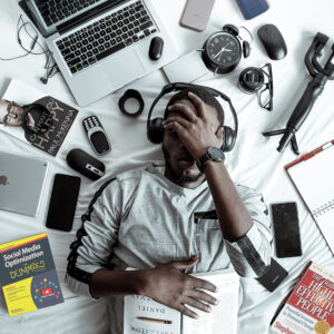 Man surrounded by tech gadgets and frustrated